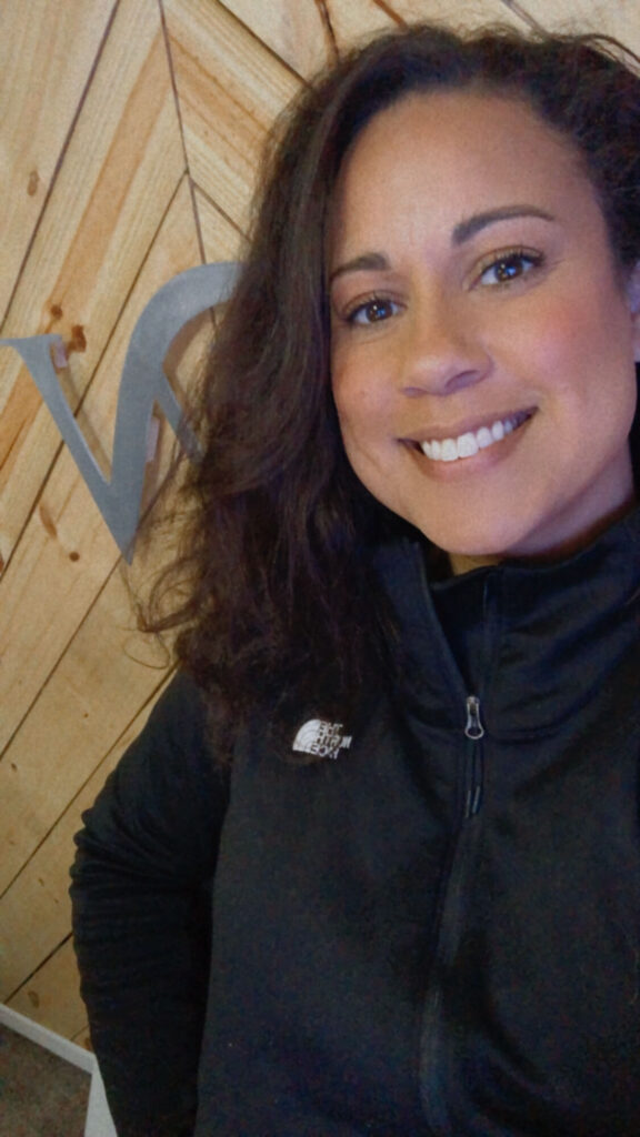 Crystal looking confident in front of her business logo. Crystal said FFF helped her stay in business and continue her entrepreneur's journey.