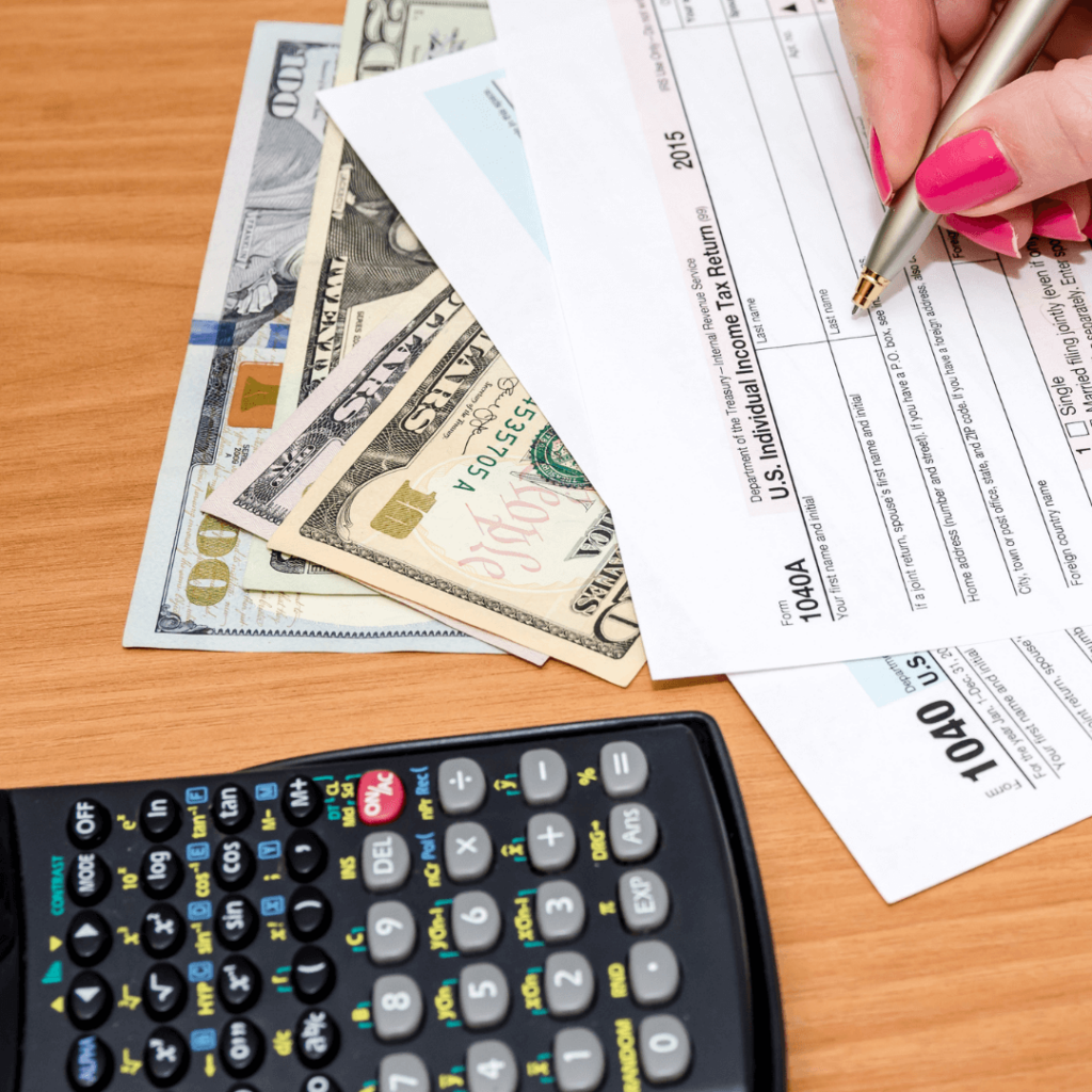 A top down view of a woman filling out an income tax return form.
