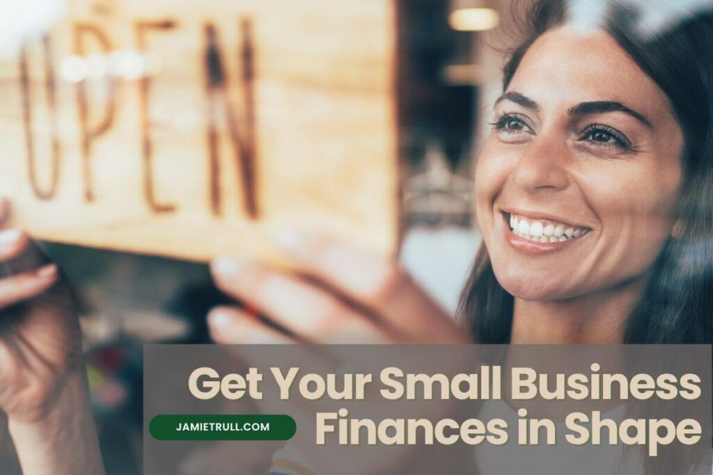 Smiling woman hanging an "open" sign on her small business door, representing successful business operations. Text overlay reads “Get Your Small Business Finances in Shape.” The image conveys themes of managing labor budget, tracking how much revenue comes in, planning for projected revenue, and focusing on net income to achieve financial success.